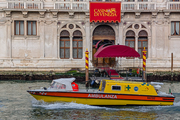 Ambulance speeds past the Casino di Venezia on Venice's Grand Canal.